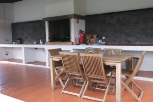 a kitchen with a wooden table and chairs at Sao Vicente Lodge - Atlantic Retreat in São Vicente Ferreira