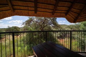 a porch with a wooden bench on a balcony at Red Sands Country Lodge in Kuruman
