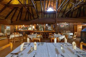 a restaurant with tables and chairs in a room at Red Sands Country Lodge in Kuruman