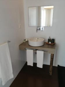 a bathroom with a sink and a mirror and towels at Sao Vicente Lodge - Atlantic Retreat in São Vicente Ferreira