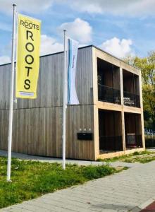 a building with two flags in front of it at ROOTS Tiny House in Tilburg