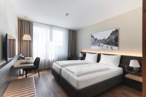 um quarto de hotel com uma cama grande e uma secretária em Hotel one66 (free parking garage) em St. Gallen