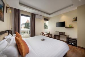 a bedroom with a white bed and a large window at Sapphire Sapa Hotel in Sapa
