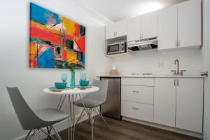 a kitchen with white cabinets and a table and chairs at Spinnaker Inn of Naples in Naples