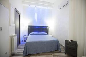 a bedroom with a blue bed in a room at Napoli Garibaldi Square in Naples