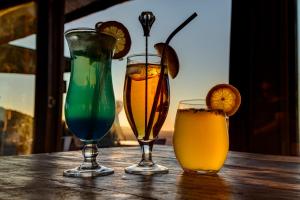 cuatro bebidas sentadas en una mesa de madera en Kanaan Desert Retreat en Helmeringhausen
