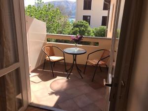 a balcony with a table and two chairs and a window at Summer rooms Baška 2 in Baška