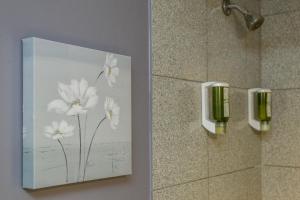 une photo de fleurs blanches sur un mur dans une salle de bains dans l'établissement Auberge de La Fontaine, à Montréal