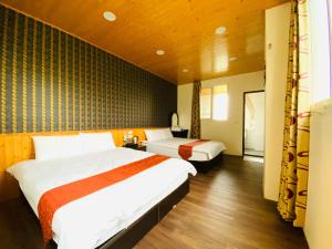 Dos camas en una habitación de hotel con dos camas. en Mini Home B&B, en Kangle 74 fotos más