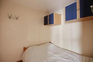 1 dormitorio pequeño con 1 cama y 2 ventanas en LOCATION APPARTEMENT CENTRE STATION SAINT JEAN D'AULPS STATION - 6 Personnes - RELAIS S1, en Saint-Jean-dʼAulps