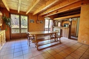 聖讓多普斯的住宿－GRAND APPARTEMENT - WIFI -SAINT JEAN D'AULPS - 12 Personnes - HIRONDELLE，一个带木桌和椅子的大厨房