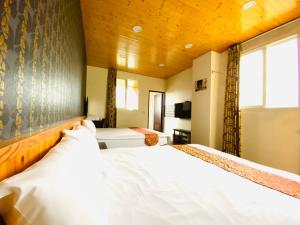 Un dormitorio con una gran cama blanca en una habitación. en Mini Home B&B, en Kangle