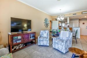 a living room with two chairs and a flat screen tv at TOPS'L Summit in Destin