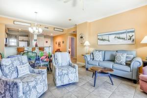 a living room with blue couches and chairs at TOPS'L Summit in Destin