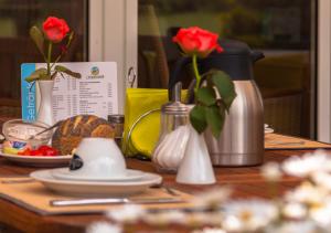 einen Holztisch mit Blumen in Vasen auf einem Tisch in der Unterkunft Lindenhof Hotel Garni in Sulsdorf auf Fehmarn
