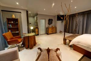 a bedroom with a bed and a desk and a chair at Na’ankusê @ Utopia in Windhoek