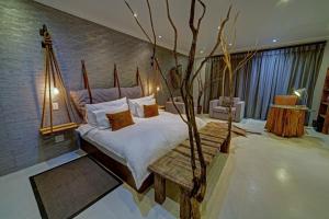 a bedroom with a bed with a tree in it at Na’ankusê @ Utopia in Windhoek