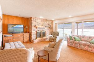 Linger Longer Lakeside Cottage في Oroville: غرفة معيشة مع أريكة وتلفزيون