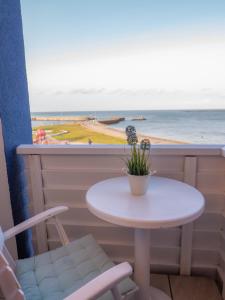 a table and two chairs and a window with the ocean at Haus Nickels in Helgoland