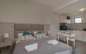 a bedroom with a large bed with two pillows on it at Casa 77 Zante by Karras Hotels in Zakynthos Town