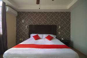 马德罗城Hotel Maria Elena的卧室里有一张大床，配有红色枕头