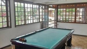 a pool table in a room with windows at Casa Temporada Arraial do Cabo in Arraial do Cabo