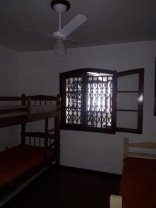 een kamer met een raam en een plafondventilator bij Casa Temporada Arraial do Cabo in Arraial do Cabo