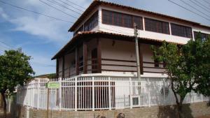 een huis met een wit hek ervoor bij Casa Temporada Arraial do Cabo in Arraial do Cabo