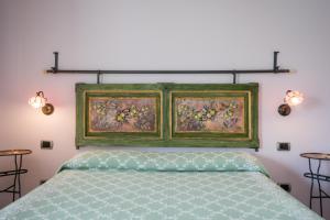 Masseria Santa Lucia في أغنون: غرفة نوم بسرير مع لوحة فوقها