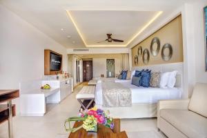 Habitación de hotel con cama grande y sofá en Royalton Riviera Cancun, An Autograph Collection All-Inclusive Resort & Casino, en Puerto Morelos