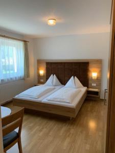 a bedroom with a large bed with white sheets at Haus Doppler in Sankt Michael im Lungau