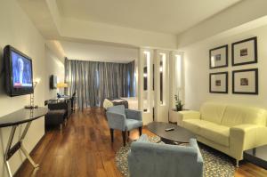 Holiday Inn Santo Domingo, an IHG Hotel في سانتو دومينغو: غرفة معيشة مع أريكة وتلفزيون في غرفة