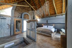 um quarto com uma cama num quarto com tectos em madeira em Naankuse Lodge em Windhoek