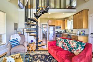 a living room with a red couch and a spiral staircase at Oceanfront Cottage with Deck and Secluded Beach Access! in Yachats