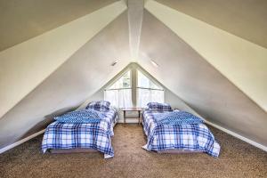 a attic room with two beds and a window at Oceanfront Cottage with Deck and Secluded Beach Access! in Yachats