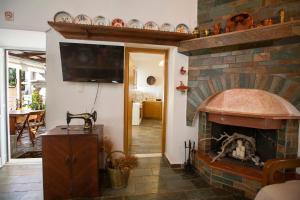 sala de estar con chimenea de ladrillo y TV de pantalla plana en Arch Villa en Fánai