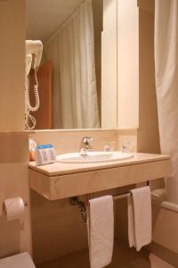 科尼爾－德拉弗龍特拉的住宿－加比光之海岸酒店，一间带水槽和镜子的浴室