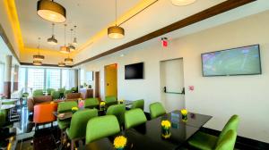 una sala conferenze con sedie verdi e schermo di proiezione di Holiday Inn Santo Domingo, an IHG Hotel a Santo Domingo
