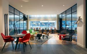 a living room with chairs and a couch and tables at citizenM Zürich in Zurich