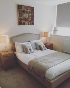 um quarto com uma cama grande e 2 mesas de cabeceira em Portfolio Apartments - Stevenage Town Centre em Stevenage
