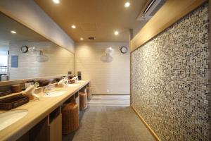 a bathroom with two sinks and a large mirror at Dormy Inn Miyazaki Natural Hot Spring in Miyazaki
