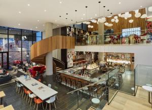 a view of the lobby of a restaurant with tables and chairs at citizenM New York Bowery in New York