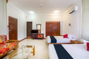 une chambre d'hôtel avec deux lits et un canapé dans l'établissement Hotel Adelita, à Zihuatanejo