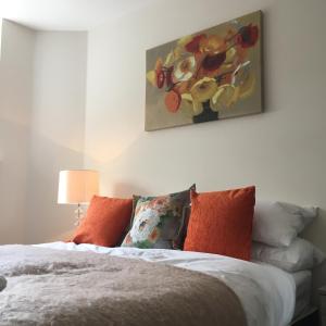 a bedroom with a bed with a painting on the wall at Portfolio Apartments - Stevenage Town Centre in Stevenage
