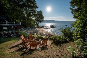 um grupo de cadeiras sentadas na margem de um lago em The Juliana Resort em Lake George