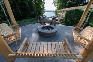 two wooden benches sitting on a patio with a fire pit at The Juliana Resort in Lake George