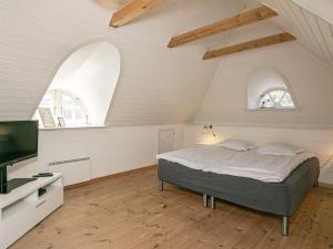 ブラーバンドにあるFour-Bedroom Holiday home in Blåvand 5のベッドルーム1室(ベッド1台、アーチ型の窓2つ付)