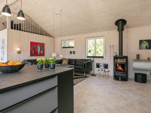 a living room with a kitchen and a stove at 7 person holiday home in Bl vand in Blåvand