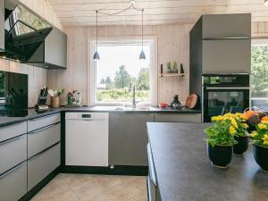 uma cozinha com uma mesa com flores em 7 person holiday home in Bl vand em Blåvand