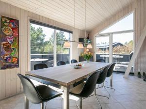 uma sala de jantar com uma mesa de madeira e cadeiras em 7 person holiday home in Bl vand em Blåvand
